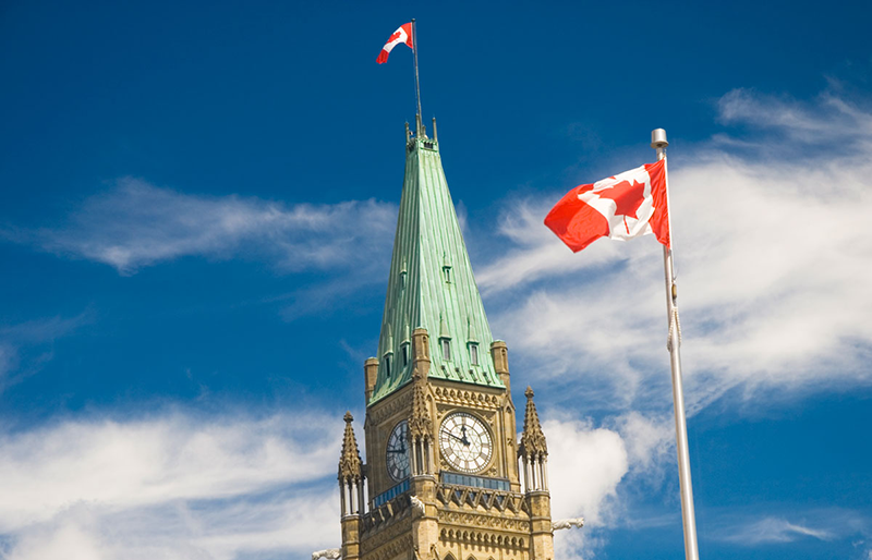 Canadian flag above parliament building